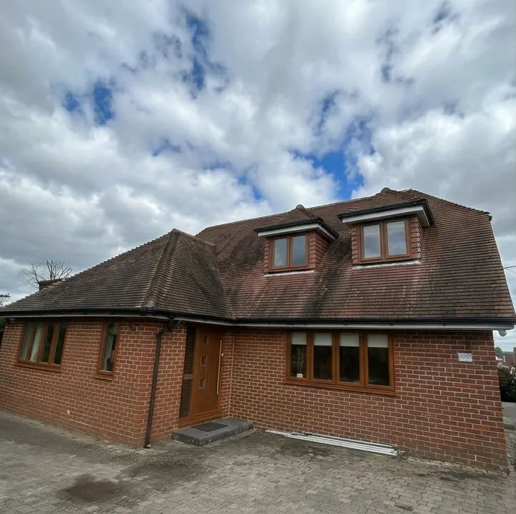 Detached house with a dark, weathered roof before cleaning