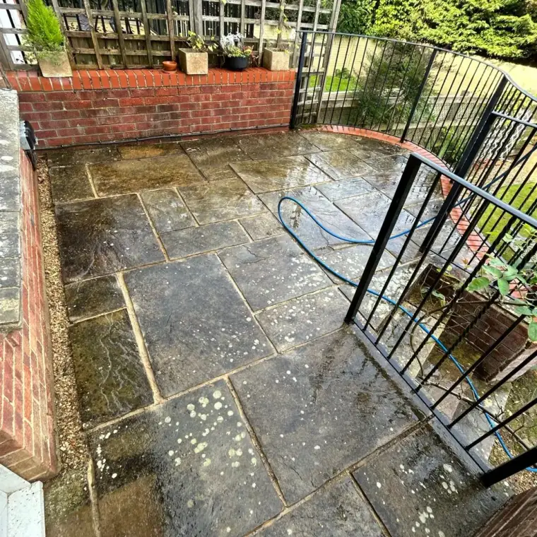 Dark, spotted patio slabs before cleaning